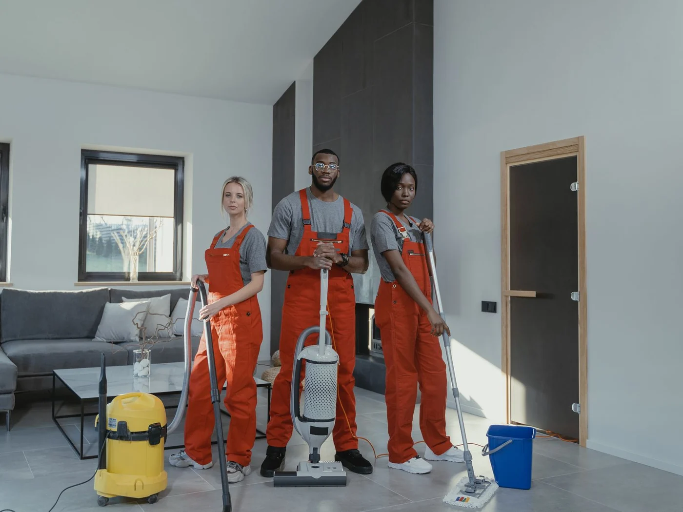 Cleaning crew with vacuums and mops in an interior prepared for a new occupant